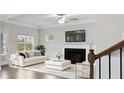 Bright living room with a fireplace, white sofa, and a view to the outside at 5103 Woodline View Ln, Auburn, GA 30011