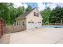 Detached two car garage with an upper level, white doors, and an extra parking pad at 96 Grover Way, Dallas, GA 30157