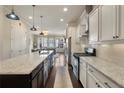 Open-concept kitchen with white cabinets, stainless steel appliances, and a view into the living area at 1671 Hammock Dr, Smyrna, GA 30080
