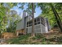 View of home's back with screen porch, brick and gray siding, and wooden fence at 535 Emerald Pkwy, Sugar Hill, GA 30518