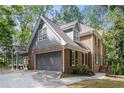 Brick two-story home boasts a gray three-car garage, blue gabled roof, and landscaped yard at 535 Emerald Pkwy, Sugar Hill, GA 30518