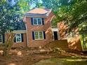 Traditional brick home with black shutters and mature trees surrounding the property at 535 Emerald Pkwy, Sugar Hill, GA 30518