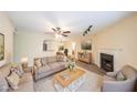 Comfortable living room featuring neutral tones, a ceiling fan, and a cozy fireplace at 1206 Canyon Point Cir, Roswell, GA 30076
