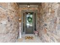 Inviting front entry with a stone surround, decorative wreath, and a charming 'hello' doormat at 1074 Heyward Way, Alpharetta, GA 30009