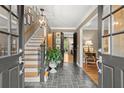 Elegant foyer featuring slate floors, staircase, and view through to the living area at 1328 Wyntercreek Rd, Atlanta, GA 30338