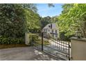 Long driveway leading to an elegant home, visible through a black iron gate with manicured hedges at 1658 Mount Paran Nw Rd, Atlanta, GA 30327