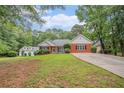Inviting exterior view of a well-maintained home with a spacious front yard and mature trees at 1721 Druids Se Xing, Conyers, GA 30013
