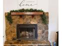 Living room fireplace with stone surround, wooden mantle, and seasonal decorations at 727 Regina Ct, Lawrenceville, GA 30043