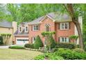 Beautiful brick home with lush landscaping, mature trees, and an attached garage at 1894 Whitehawk Ct, Lawrenceville, GA 30043