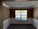 Bright living room featuring neutral carpet, beautiful wainscoting, and large windows at 4234 Winston Cir, Atlanta, GA 30349