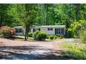 Beautiful one-story home with black shutters and colorful landscaping along a private driveway surrounded by mature trees at 1530 Mcbrayer Rd, Temple, GA 30179