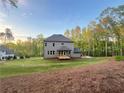 Expansive backyard with lush green lawn, mature trees and a view of the home's back elevation at 1005 Liberty Springs Dr, Woodstock, GA 30188