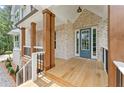 Inviting front porch featuring wooden columns, brick accents and a blue front door at 1005 Liberty Springs Dr, Woodstock, GA 30188