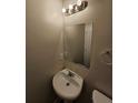 Cozy powder room featuring a pedestal sink, decorative mirror, and modern light fixture at 4316 Sw Notting Hill Sw Dr, Atlanta, GA 30331