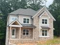 Charming two-story brick home featuring a covered front porch, well-manicured landscaping, and a classic architectural design at 1025 Liberty Springs Dr, Woodstock, GA 30188