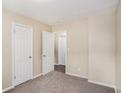 Bedroom with three doors showcasing neutral colored walls and carpet flooring at 310 Oak Se Dr, Atlanta, GA 30354