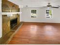 Spacious living room with hardwood floors, a stone fireplace, and natural light from windows at 4357 Treeline Way, Douglasville, GA 30135