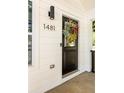 Modern black front door featuring updated hardware and decorative wreath with natural lighting at 1481 Almont Sw Dr, Atlanta, GA 30310