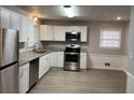 Updated kitchen with white cabinets, stainless steel appliances, and granite countertops at 2858 Davidson Dr, Lithonia, GA 30058