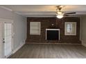 Spacious living room featuring a brick fireplace, modern flooring, and double doors to the outside at 2858 Davidson Dr, Lithonia, GA 30058