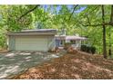 Charming home featuring a two-car garage, a landscaped yard and a wooded lot at 7320 Oak Arms Dr, Villa Rica, GA 30180