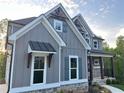 Beautiful home featuring gray siding, white trim, stone accents, and charming architectural details at 1021 Liberty Springs Dr, Woodstock, GA 30188