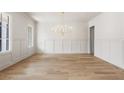 Spacious dining room with bright natural light, sleek hardwood floors and paneled walls at 117 Owens Mill Pl, Canton, GA 30115