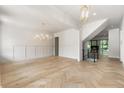 Bright and airy living room featuring light hardwood floors, modern lighting, and paneled walls at 117 Owens Mill Pl, Canton, GA 30115