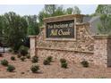 Stone community sign for The Enclave at Mill Creek, set amidst landscaping at 1924 William Glen St, Dacula, GA 30019