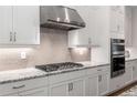Modern kitchen featuring sleek white cabinets, granite countertops, and stainless steel appliances at 2004 Haley Walk, Woodstock, GA 30188
