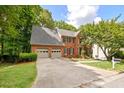 Beautiful brick home featuring a three car garage and double driveway at 2355 Twelvestones Dr, Roswell, GA 30076