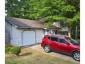 View of home showing well-maintained lawn, garage and front shrubs at 6193 Charring Cross Ct, Lithonia, GA 30058