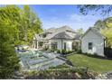 A luxurious outdoor space featuring a pristine pool, jacuzzi, and plenty of lounge seating at 214 Kenneth Drive, Alpharetta, GA 30009