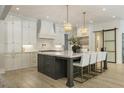 Spacious kitchen with white cabinetry, modern island, stylish light fixtures, and stainless steel appliances at 214 Kenneth Drive, Alpharetta, GA 30009