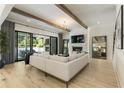 Bright living room with hardwood floors, beamed ceiling, and glass doors to outdoor fireplace at 214 Kenneth Drive, Alpharetta, GA 30009