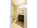 Cozy bathroom featuring tile floors, dark vanity, and a shower with a decorative green curtain at 2262 Haventree Ct, Lawrenceville, GA 30043