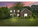 Well-manicured lawn and landscaping enhance this two-story brick home at dusk at , Cumming, GA 30041