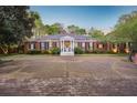 Stately brick home with a wide driveway, boasting a grand entrance with columns and mature landscaping at 289 W Paces Ferry Nw Rd, Atlanta, GA 30305
