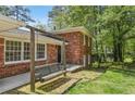 Inviting front porch features a swing for relaxation with red brick and mature landscaping at 3007 Octavia Cir, Marietta, GA 30062