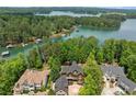 An aerial view showcases the lakefront home surrounded by lush greenery and waterfront views at 4290 Bobbins Way, Cumming, GA 30041