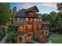 Multi-level home with expansive decks, stone base, inviting outdoor space, and natural surroundings at 4290 Bobbins Way, Cumming, GA 30041