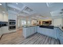 Spacious kitchen boasts white cabinets, modern stainless steel appliances, and a large granite island for cooking at 7580 Blacks Mill Rd, Cumming, GA 30028