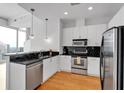 Modern kitchen featuring white cabinets, stainless steel appliances, black subway tile, and an island with countertop seating at 860 Peachtree Ne St # 2815, Atlanta, GA 30308