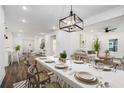 Dining room with seating for eight, modern chandelier, and open concept with kitchen and living room at 551 Lake Dr, Atlanta, GA 30354