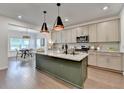 Modern kitchen with granite countertops, stainless steel appliances, and pendant lighting over island at 5650 Bergeson Ways, Cumming, GA 30028