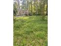 Side view of the home with a well-maintained lawn and natural setting at 61 Kathy Ln, Temple, GA 30179