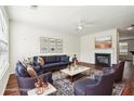 Bright living room with a fireplace, ceiling fan, dark wood floors, and stylish blue furniture on a decorative area rug at 3505 Chattahoochee Summit Se Ln # 25, Atlanta, GA 30339