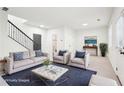 Open living room featuring hardwood floors, a gray couch with blue pillows, and natural light from two windows at 3505 Chattahoochee Summit Se Ln # 25, Atlanta, GA 30339