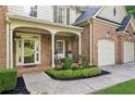 Charming front porch with rocking chairs and a meticulously landscaped garden bed at 6795 Preston Glen Dr, Alpharetta, GA 30005