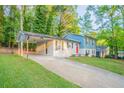 Charming two-story home with a red front door, a carport, a spacious front yard and a concrete driveway at 2046 Copperfield Cir, Decatur, GA 30035